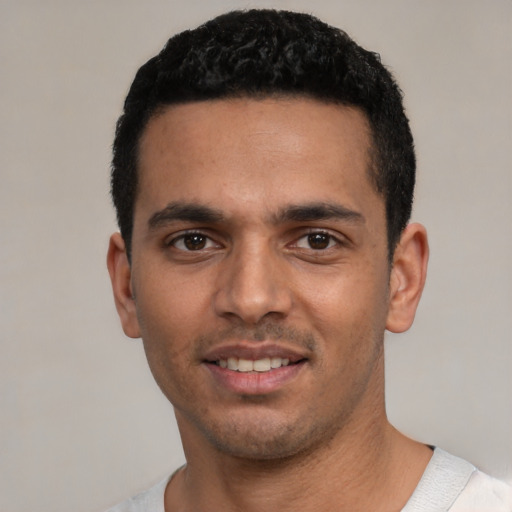 Joyful white young-adult male with short  black hair and brown eyes