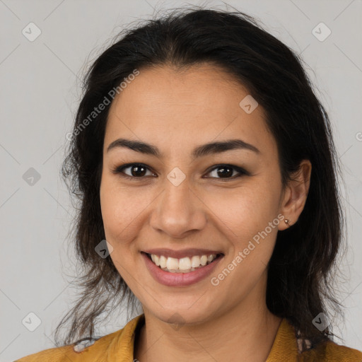 Joyful latino young-adult female with long  brown hair and brown eyes