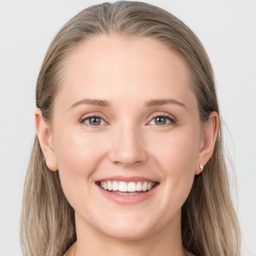 Joyful white young-adult female with long  brown hair and grey eyes