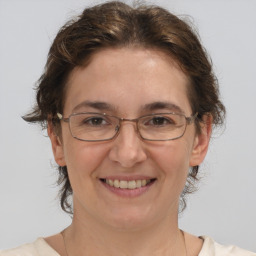 Joyful white adult female with medium  brown hair and grey eyes