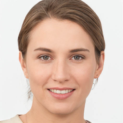 Joyful white young-adult female with medium  brown hair and grey eyes