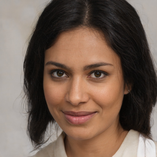 Joyful latino young-adult female with medium  brown hair and brown eyes