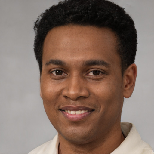 Joyful latino young-adult male with short  black hair and brown eyes