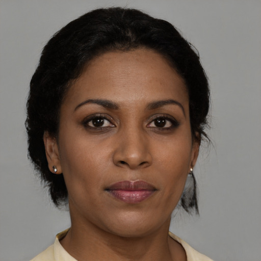 Joyful black young-adult female with short  brown hair and brown eyes