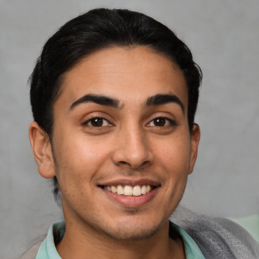 Joyful latino young-adult male with short  brown hair and brown eyes