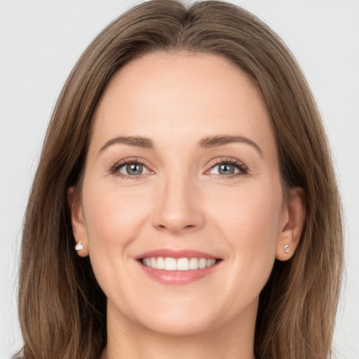 Joyful white young-adult female with long  brown hair and grey eyes