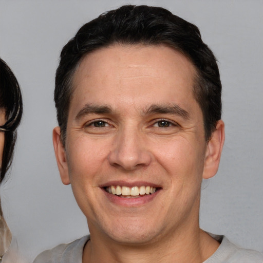 Joyful white adult male with short  brown hair and brown eyes