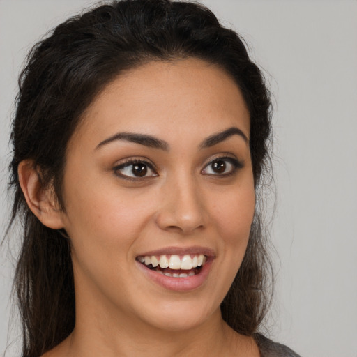 Joyful latino young-adult female with long  brown hair and brown eyes