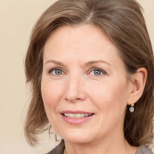 Joyful white adult female with medium  brown hair and grey eyes