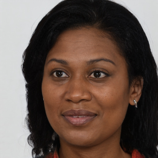 Joyful black young-adult female with long  black hair and brown eyes