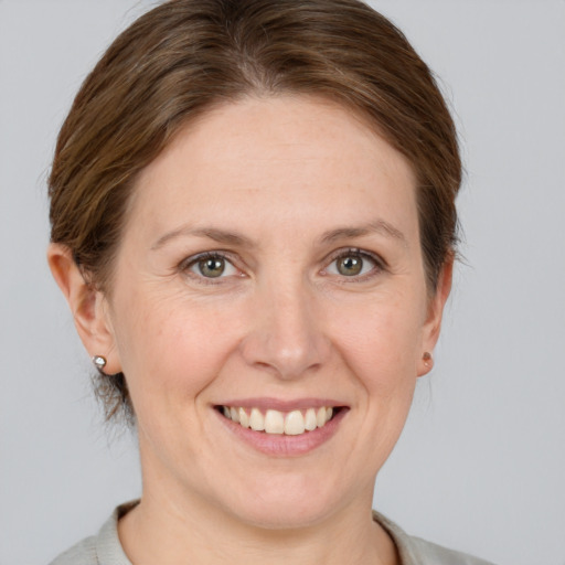 Joyful white adult female with short  brown hair and grey eyes