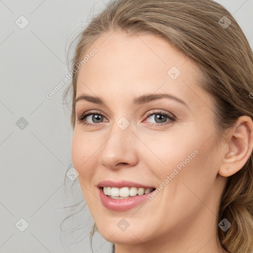 Joyful white young-adult female with long  brown hair and blue eyes