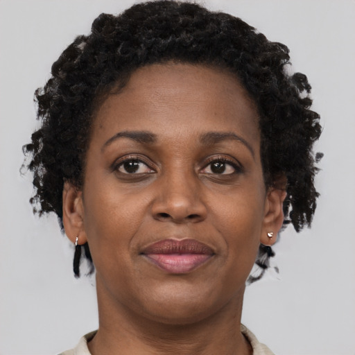 Joyful black adult female with short  brown hair and brown eyes