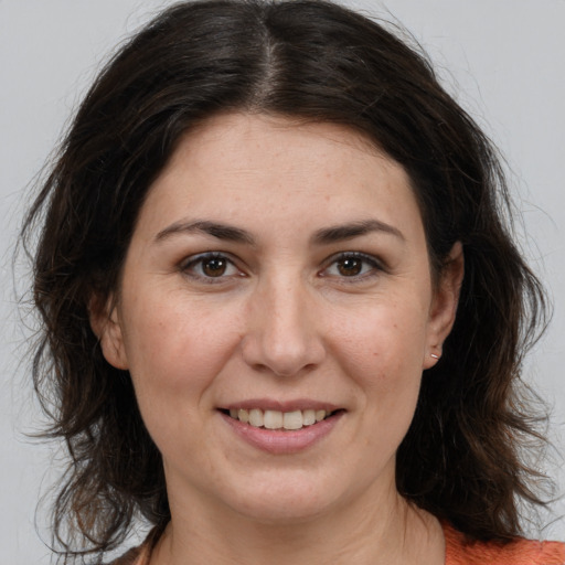 Joyful white adult female with medium  brown hair and brown eyes