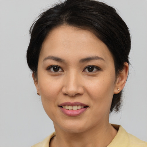 Joyful asian young-adult female with short  brown hair and brown eyes