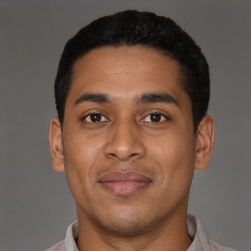 Joyful latino young-adult male with short  black hair and brown eyes