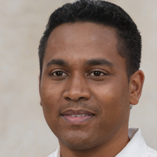 Joyful black young-adult male with short  black hair and brown eyes