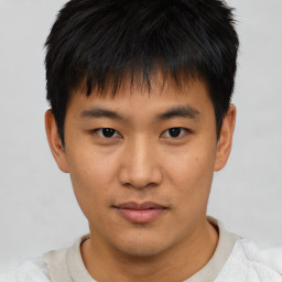 Joyful asian young-adult male with short  black hair and brown eyes