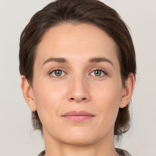 Joyful white young-adult female with medium  brown hair and grey eyes