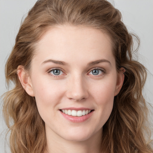 Joyful white young-adult female with long  brown hair and blue eyes