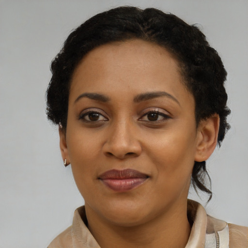 Joyful black young-adult female with short  black hair and brown eyes