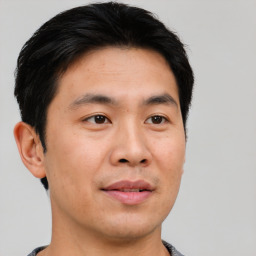 Joyful asian young-adult male with short  brown hair and brown eyes