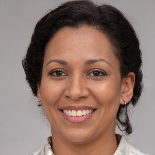 Joyful latino adult female with medium  brown hair and brown eyes