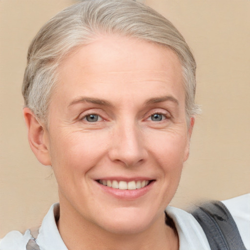 Joyful white adult female with short  blond hair and grey eyes