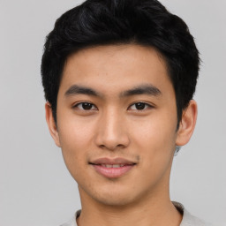 Joyful asian young-adult male with short  black hair and brown eyes