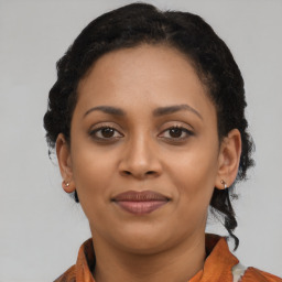 Joyful black young-adult female with short  brown hair and brown eyes