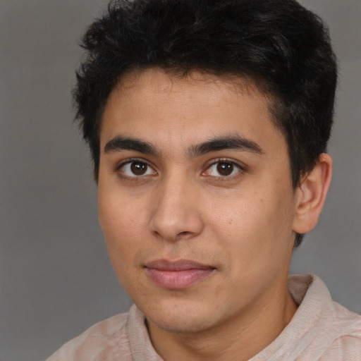 Joyful latino young-adult male with short  brown hair and brown eyes