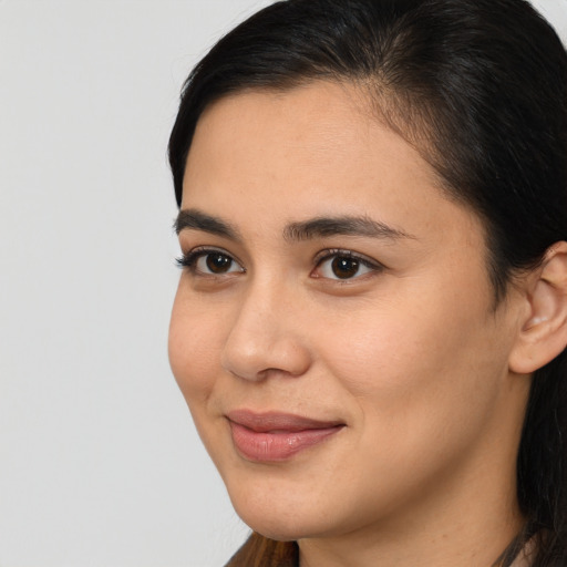 Joyful latino young-adult female with long  brown hair and brown eyes