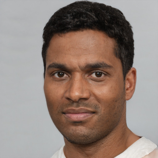 Joyful black young-adult male with short  black hair and brown eyes