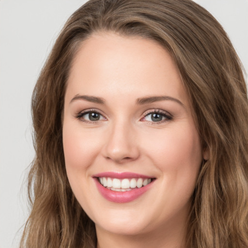 Joyful white young-adult female with long  brown hair and green eyes