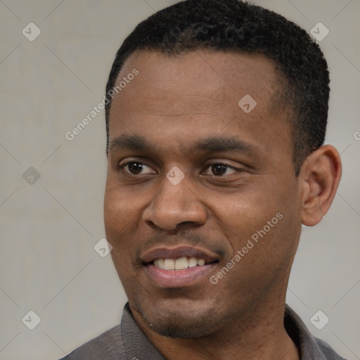 Joyful black young-adult male with short  black hair and brown eyes