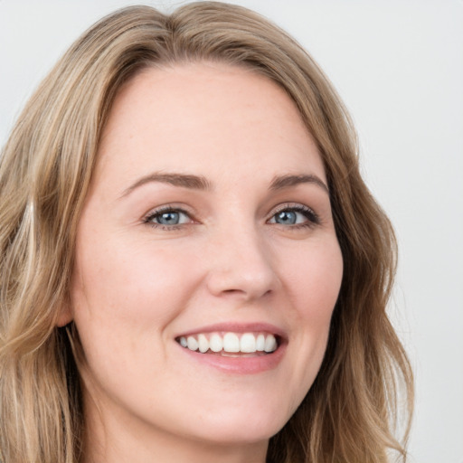 Joyful white young-adult female with long  brown hair and blue eyes