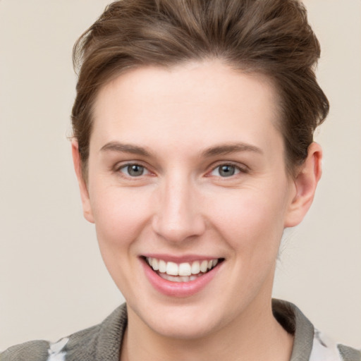 Joyful white young-adult female with short  brown hair and grey eyes