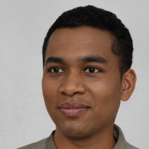 Joyful black young-adult male with short  black hair and brown eyes