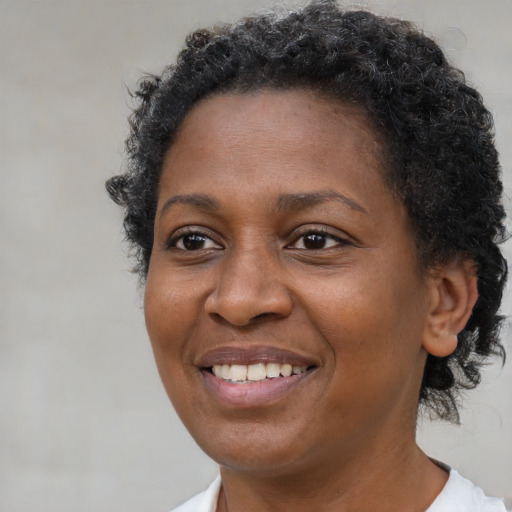 Joyful black adult female with short  brown hair and brown eyes