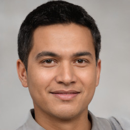 Joyful latino young-adult male with short  brown hair and brown eyes