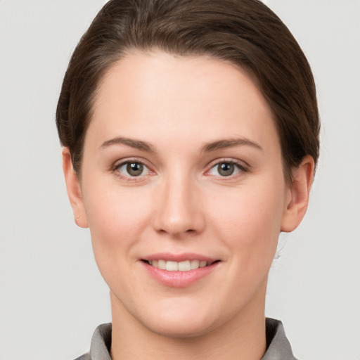 Joyful white young-adult female with short  brown hair and grey eyes