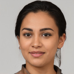 Joyful latino young-adult female with medium  brown hair and brown eyes