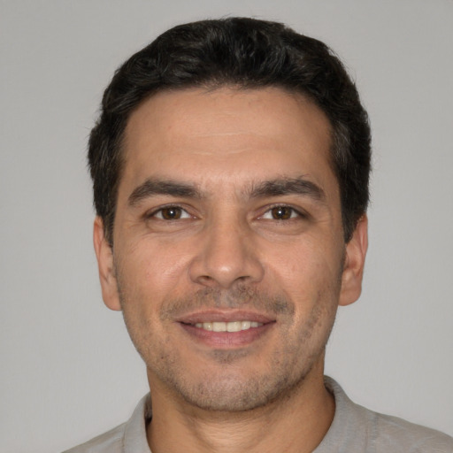 Joyful white young-adult male with short  black hair and brown eyes