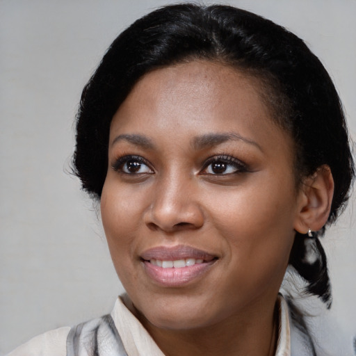 Joyful black young-adult female with medium  black hair and brown eyes