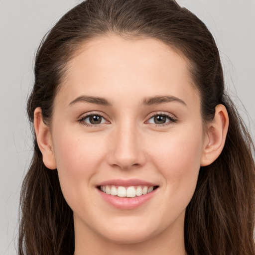 Joyful white young-adult female with long  brown hair and grey eyes