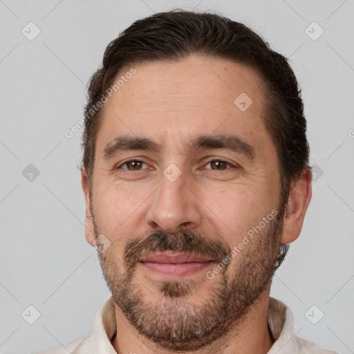 Joyful white adult male with short  brown hair and brown eyes