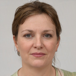 Joyful white adult female with medium  brown hair and grey eyes