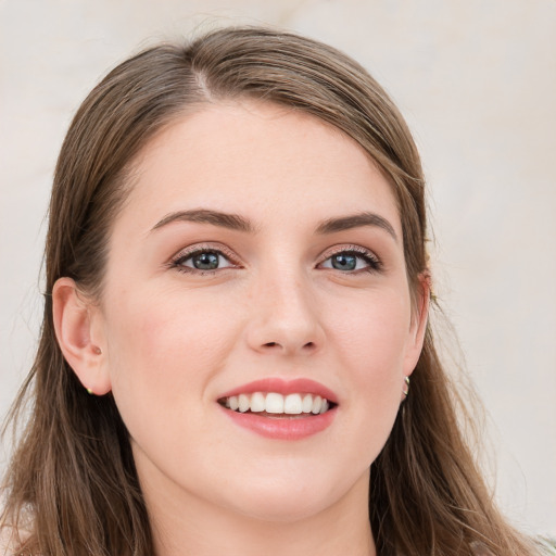 Joyful white young-adult female with long  brown hair and blue eyes