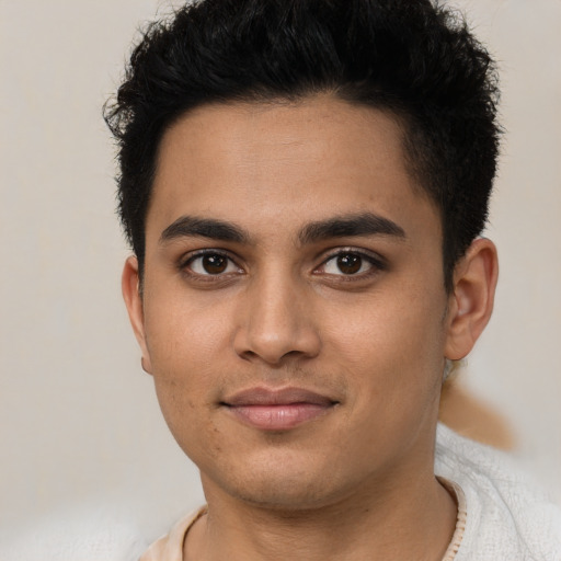 Joyful latino young-adult male with short  brown hair and brown eyes