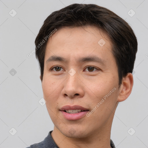 Joyful asian young-adult male with short  brown hair and brown eyes